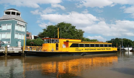 Yellow water taxi pulled up to a dock in National Harbor